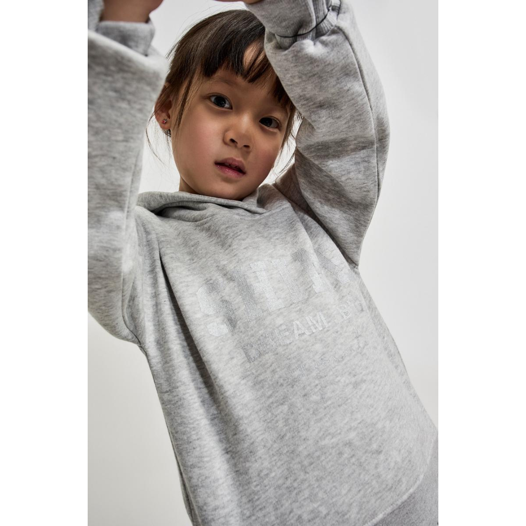 Menina a usar sweatshirt cinza com capuz e texto branco