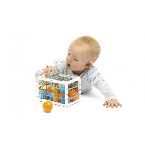 Bebé brinca com brinquedo de plástico colorido sobre fundo branco