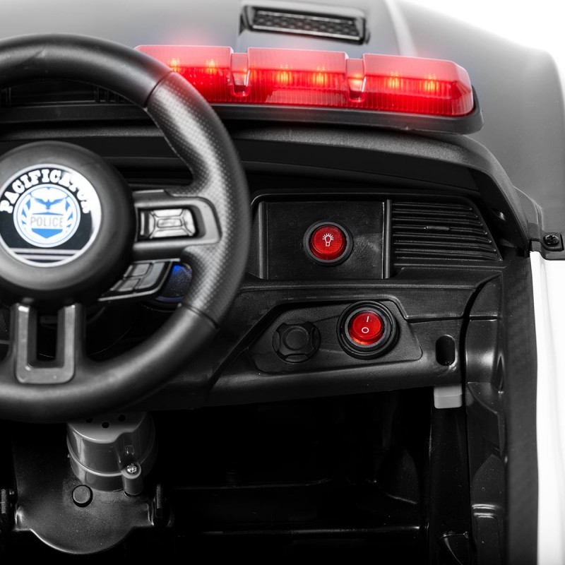 Interior do carro de brinquedo da polícia com volante preto e luzes vermelhas no painel