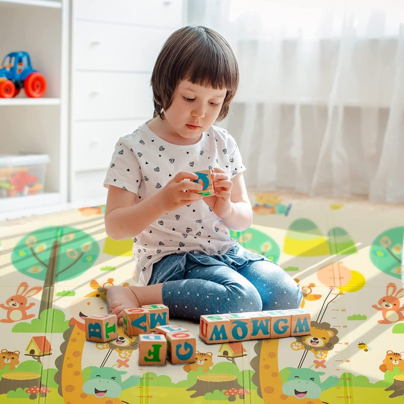 Criança a brincar com blocos de madeira coloridos sentada num tapete infantil decorado com animais e árvores