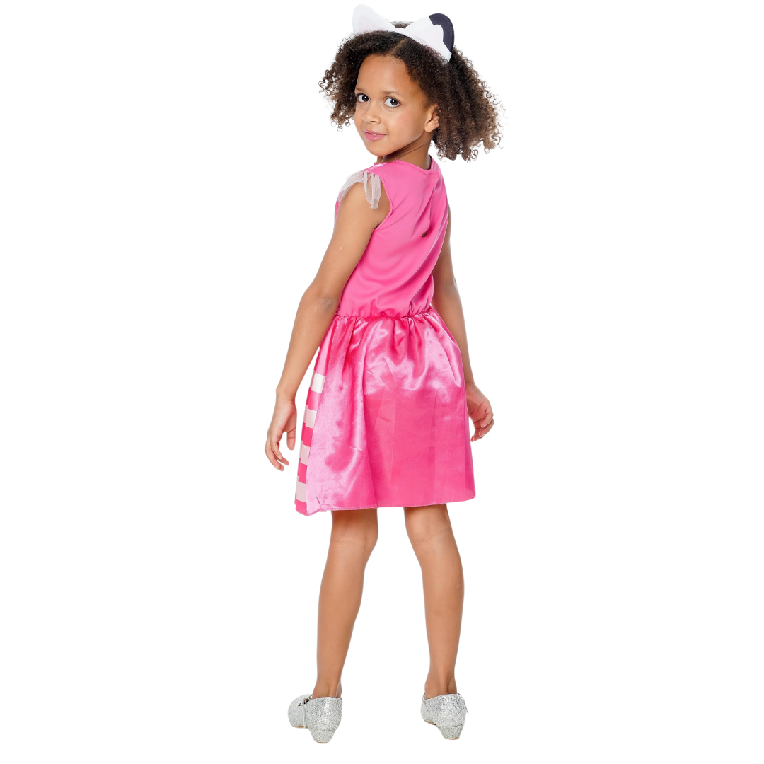 Menina vestindo vestido cor-de-rosa com saia brilhante, calçado prateado e faixa de cabelo com laço.