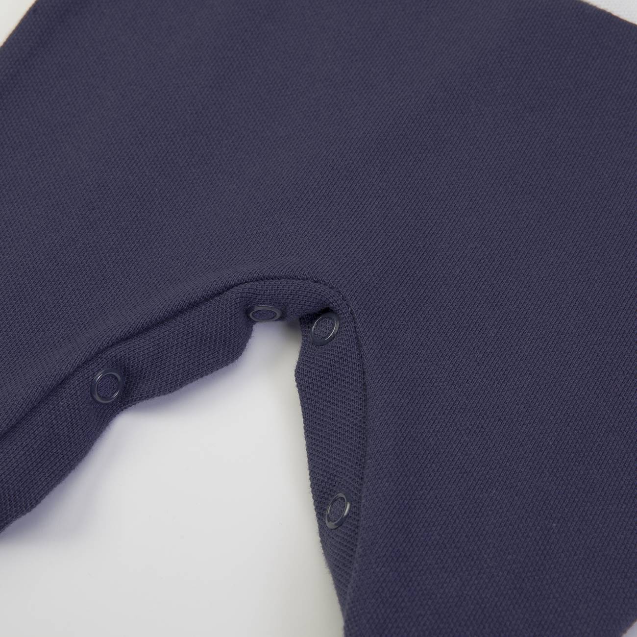 Peça de vestuário azul escuro com botões de pressão na axila