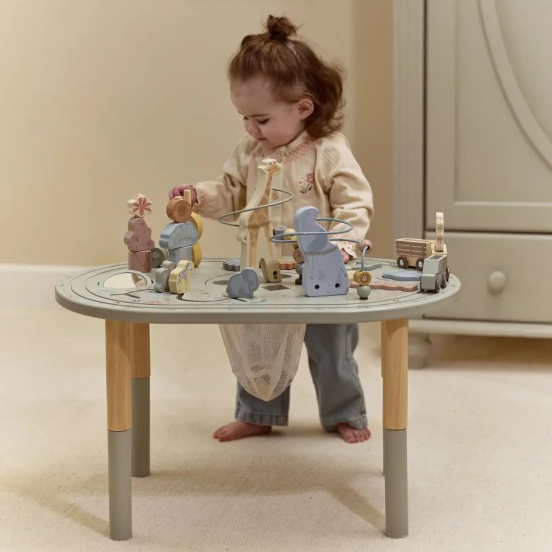 Criança a brincar com mesa de atividades em madeira e metal com brinquedos de madeira coloridos