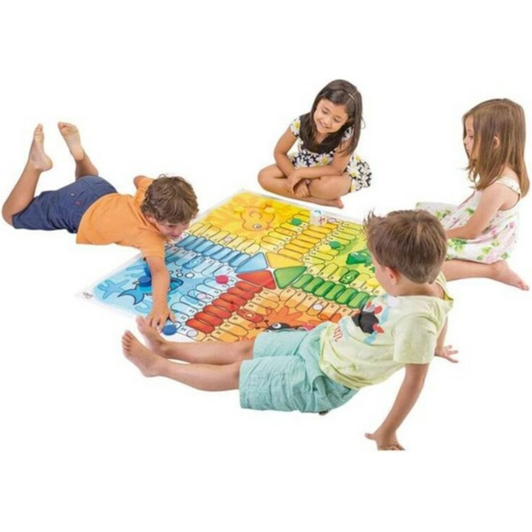 Quatro crianças a jogar com um tabuleiro colorido de jogo de tabuleiro no chão