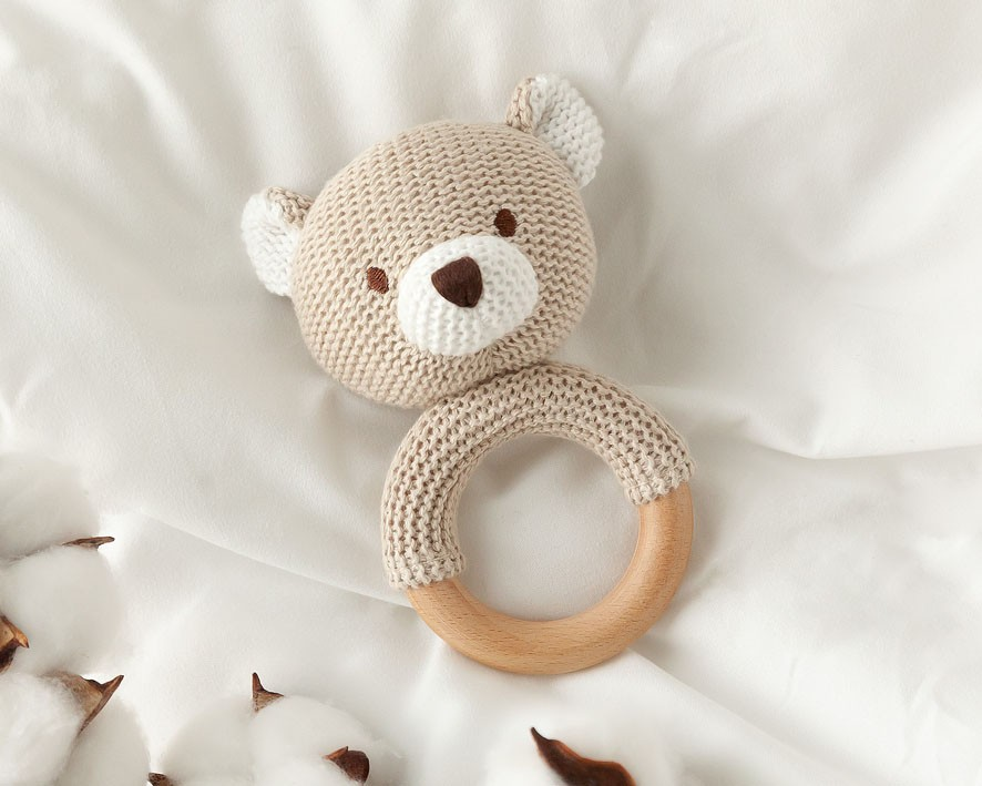 Brinquedo para bebé de cabeça de urso em crochet com base de madeira