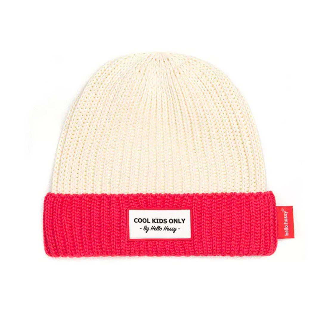 Gorro de malha creme com dobra vermelha e etiquetas com texto.