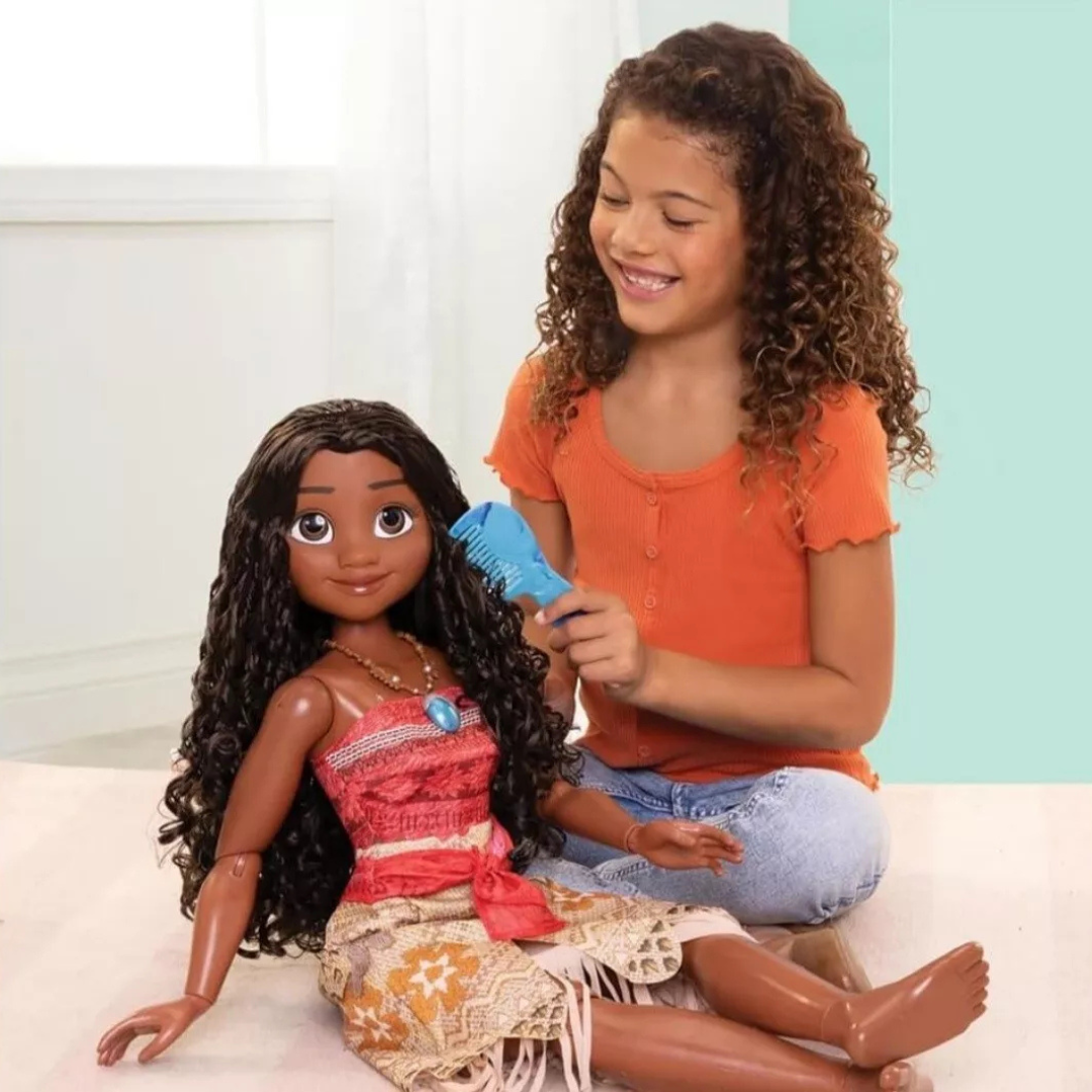 Boneca Moana com roupa tradicional e pente azul, menina a pentear-lhe o cabelo