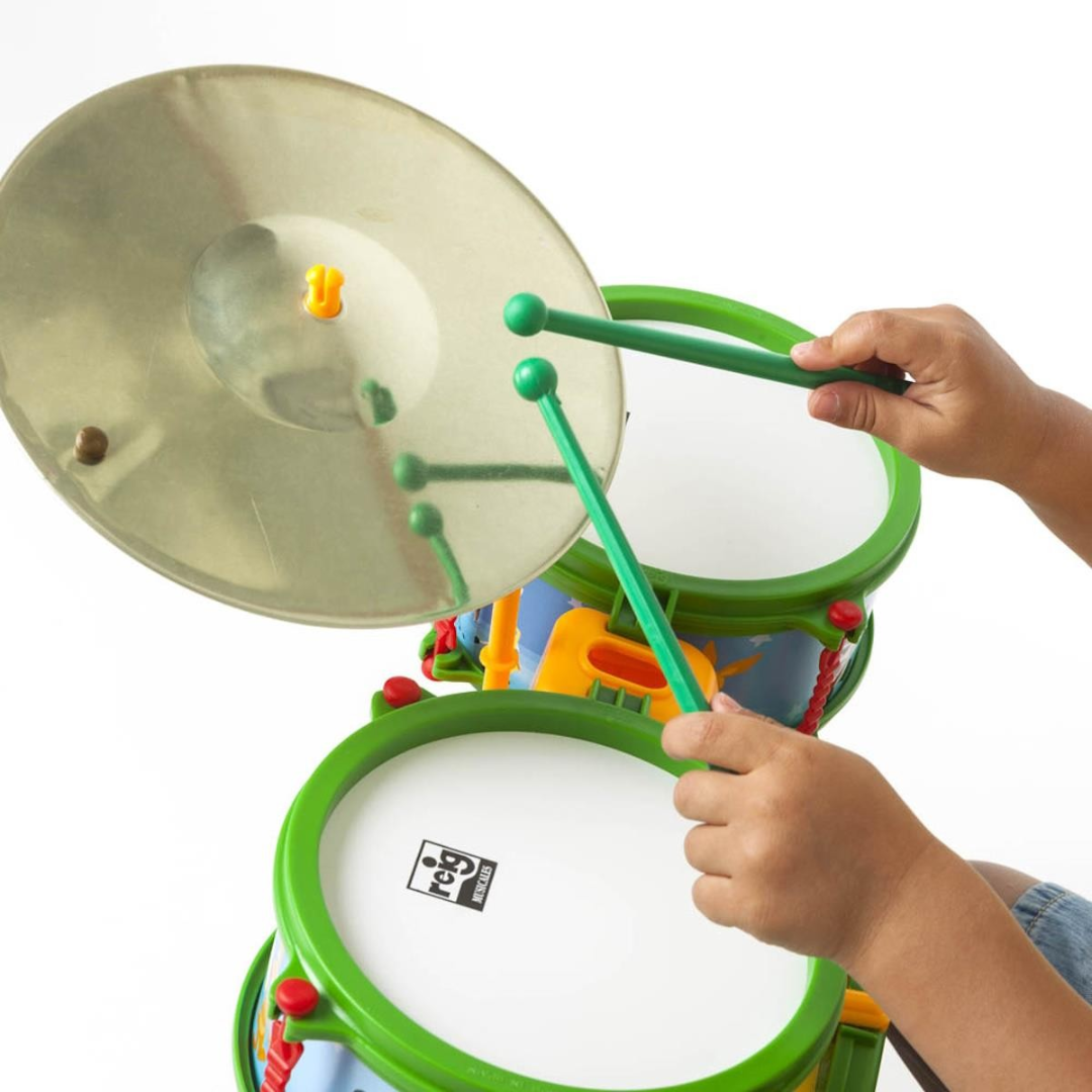 Bateria de brinquedo colorida com pratos metálicos e baquetas verdes em mãos de criança