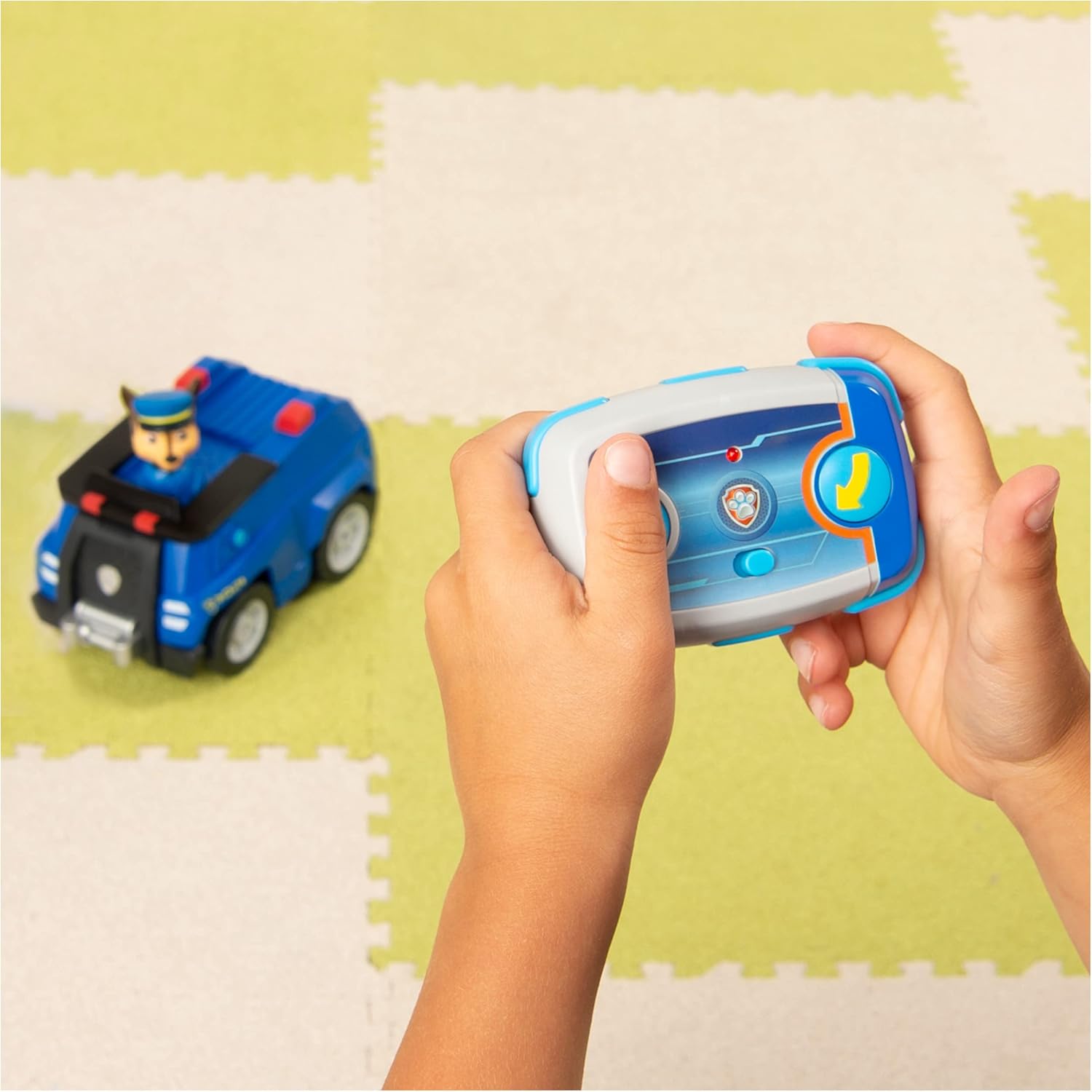 Comando de brinquedo azul e carrinho azul com figura de condutor em tapete colorido