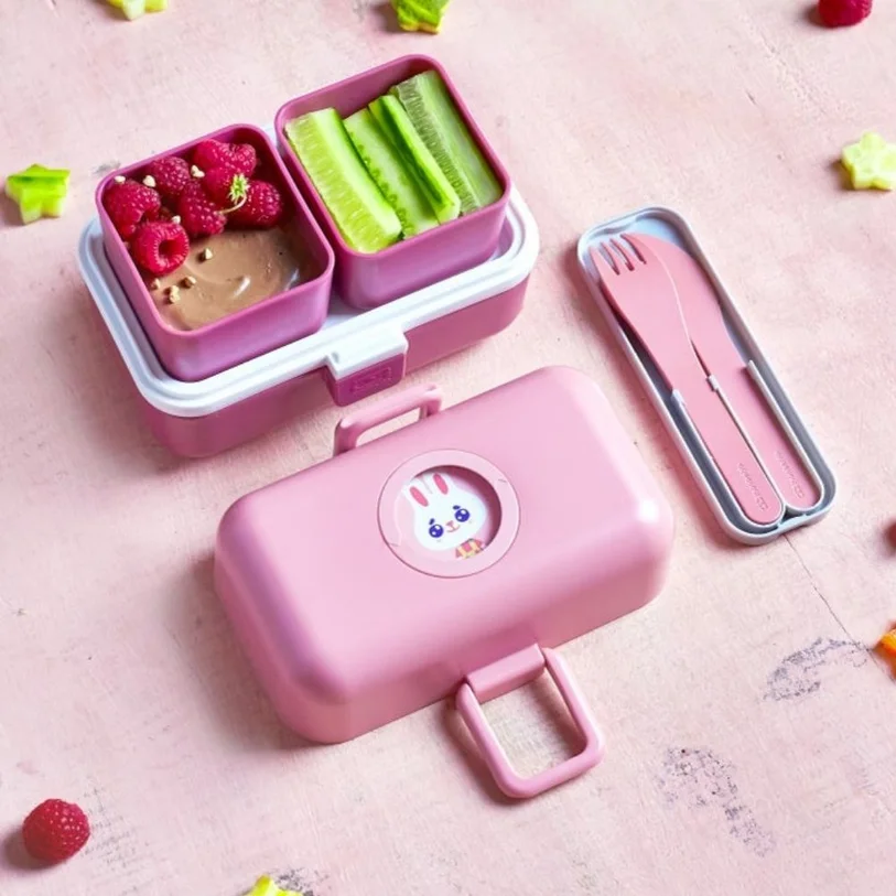 Marmita cor-de-rosa e talheres numa mesa rosa