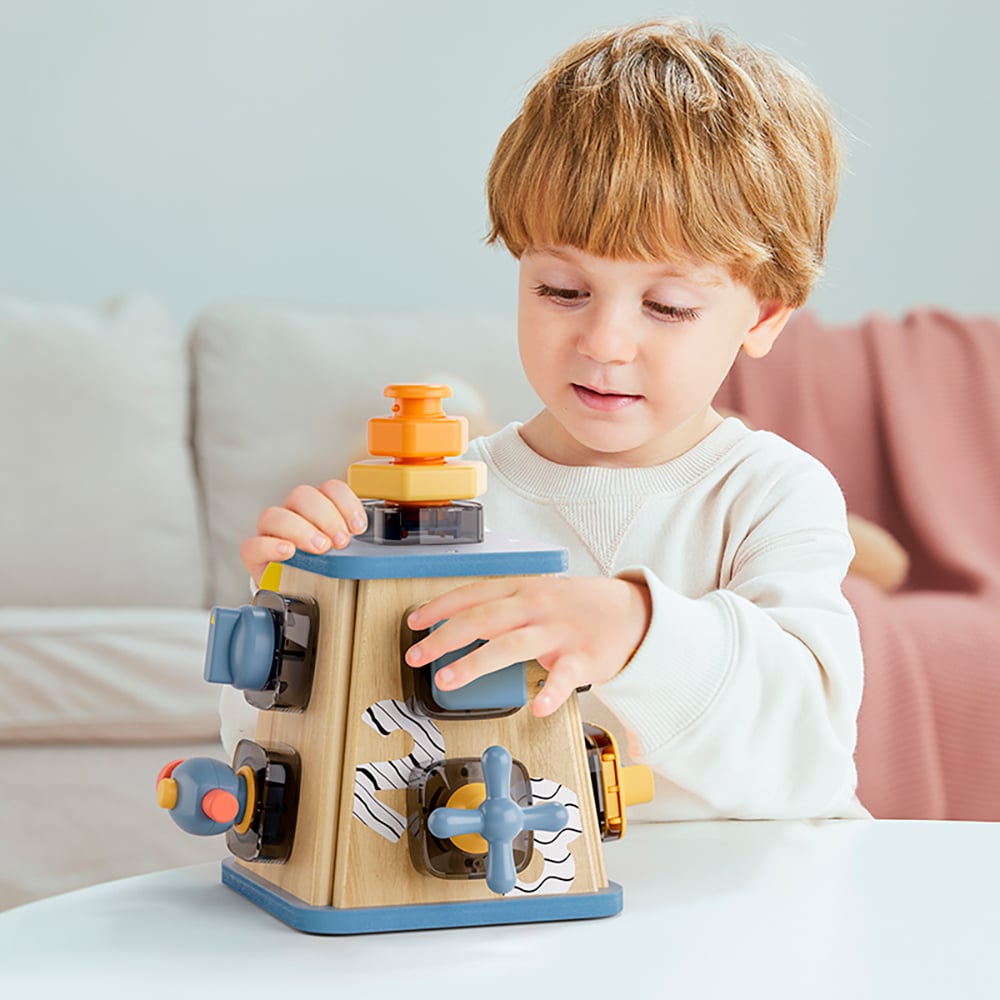 Criança a brincar com brinquedo educativo de madeira colorido numa mesa