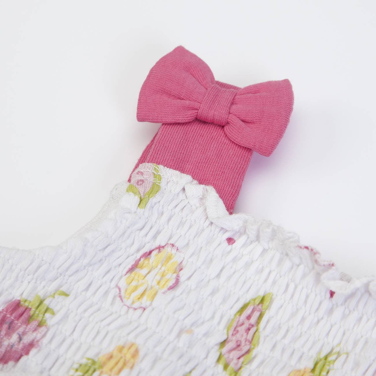 Roupa branca com padrão floral e laço rosa