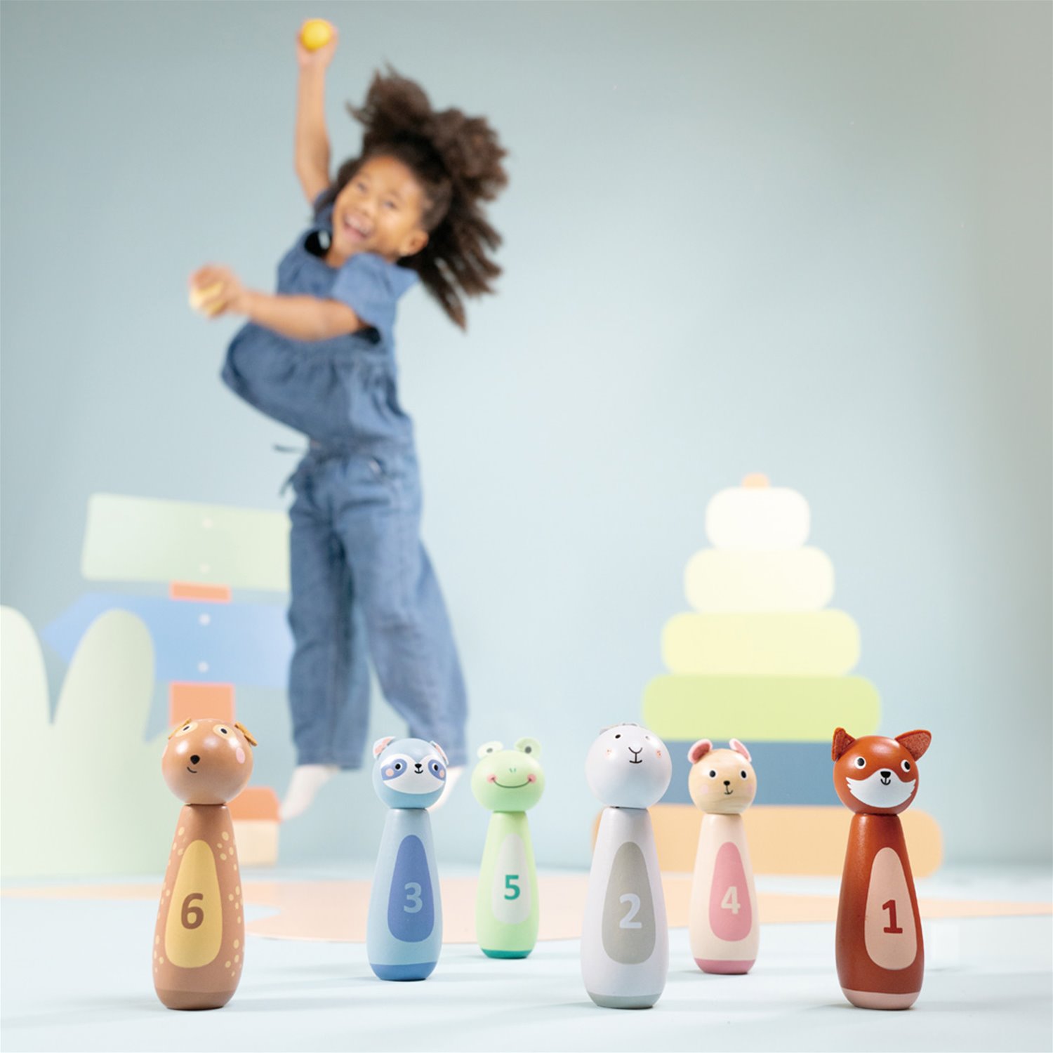 Conjunto de seis pinos de madeira com desenhos de animais e números, num quarto infantil.