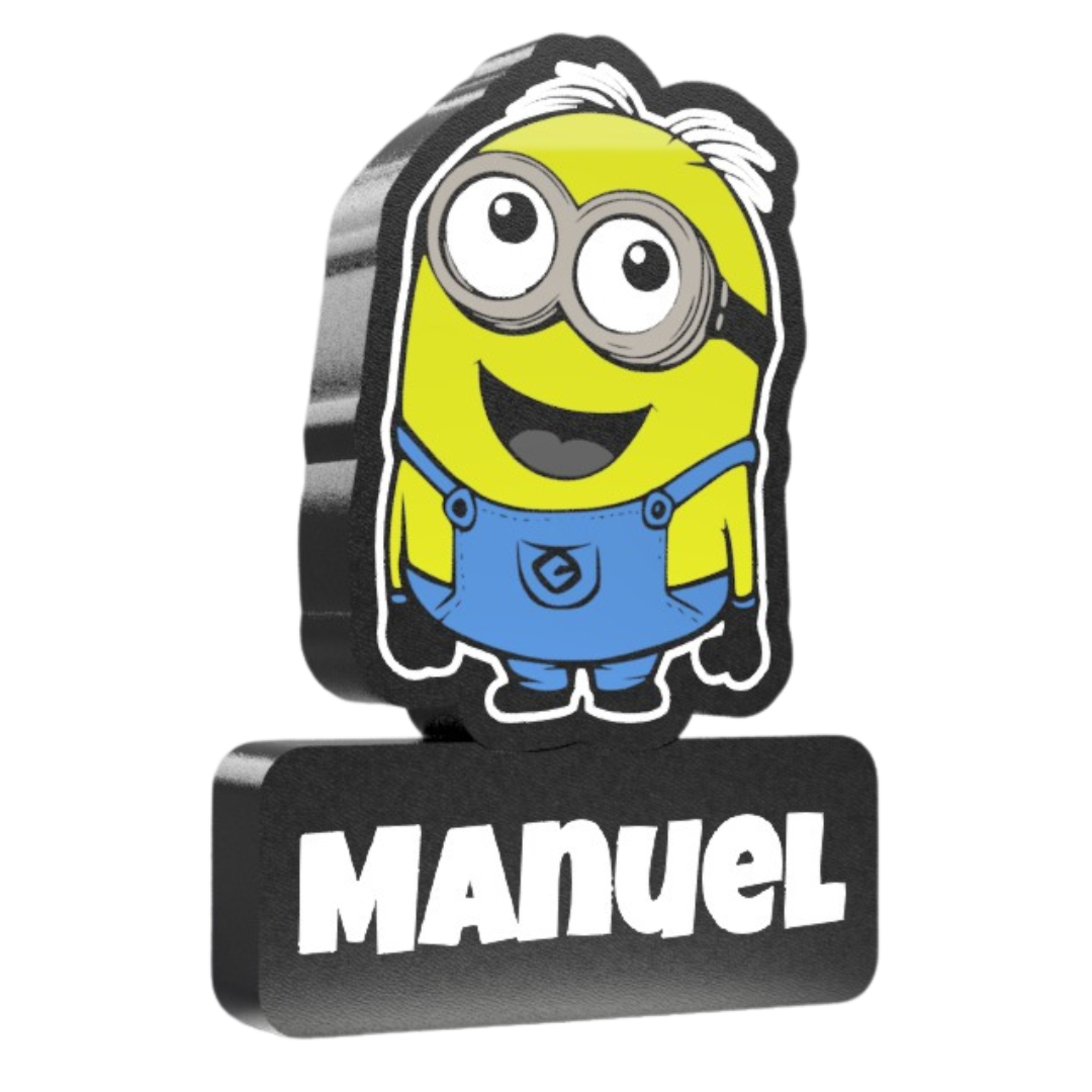 Figura de personagem amarelo estilo Minion com roupa azul e base preta com nome Manuel