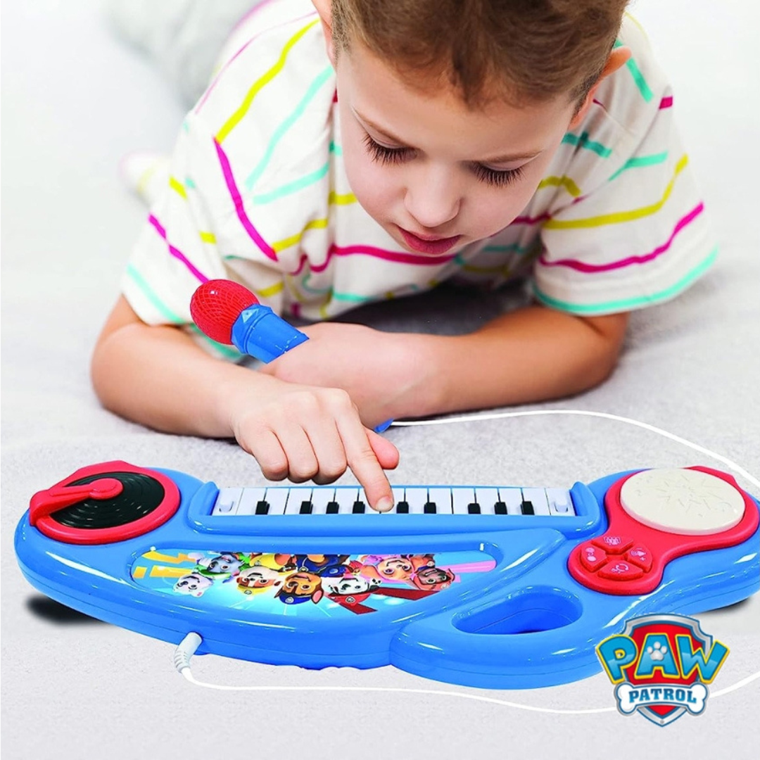 Criança a usar teclado musical infantil azul com microfone vermelho e imagem PAW PATROL