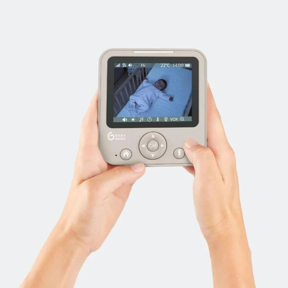 Monitor digital portátil BABY MOOV com ecrã a cores mostrando bebé a dormir num berço branco