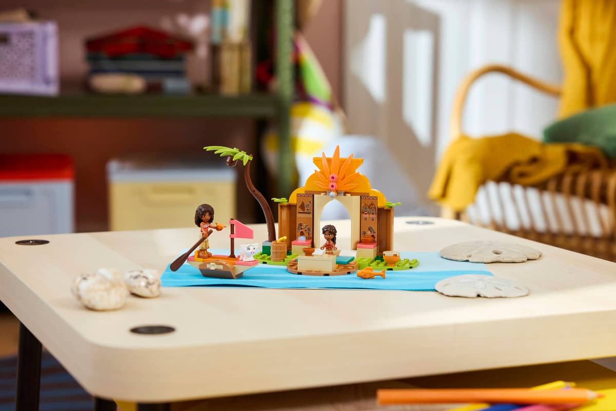Brinquedo de construção com figuras e cenário de ilha sobre mesa de madeira clara