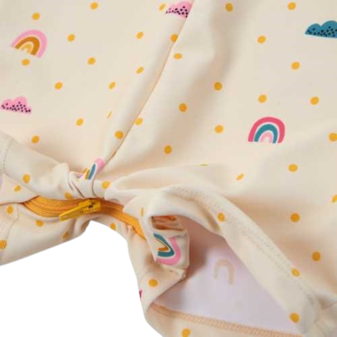 Roupa infantil com motivos de arco-íris e nuvens coloridas e fecho amarelo