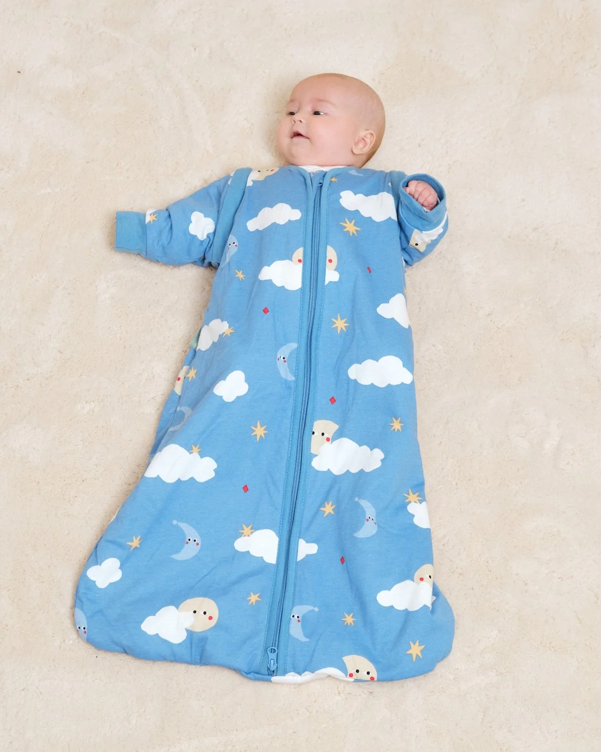 Pijama saco azul para bebé com estampado de nuvens, luas e estrelas.