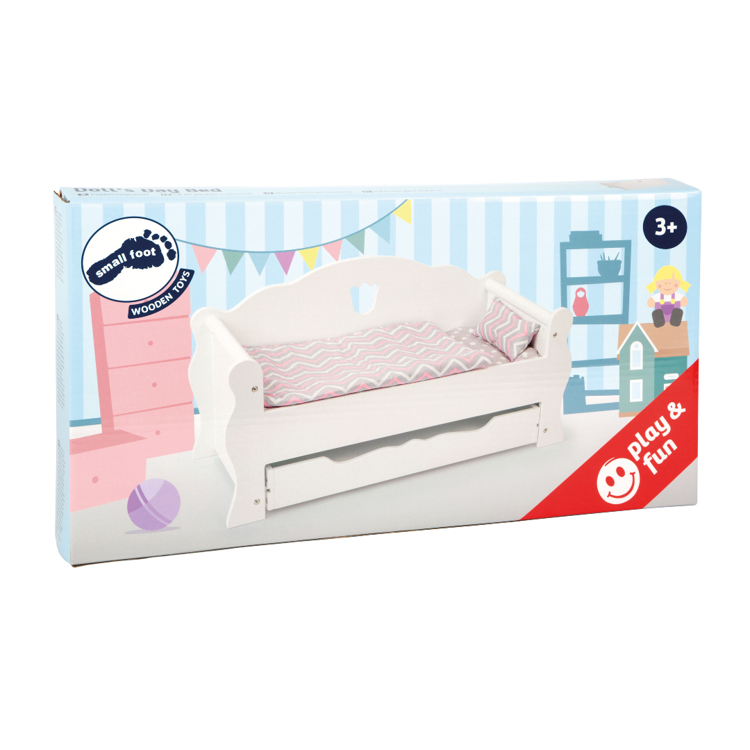 Caixa de brinquedo cama de boneca branca com almofada e colchão cinza e rosa.