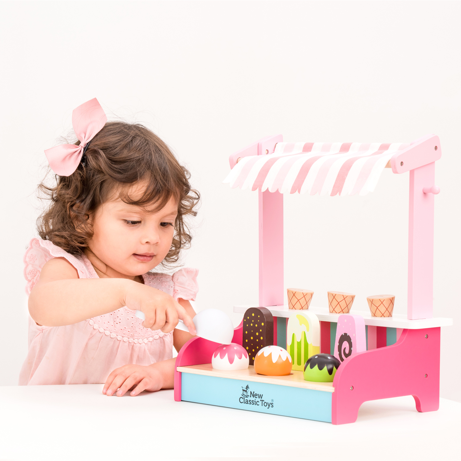 Brinquedo de madeira carrinho de gelados com criança a brincar