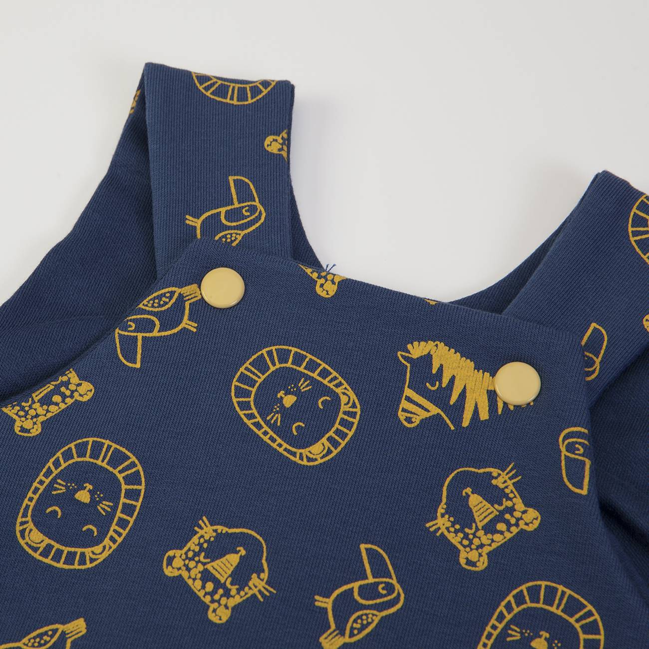 Macacão azul escuro com padrão amarelo de animais e botões amarelos