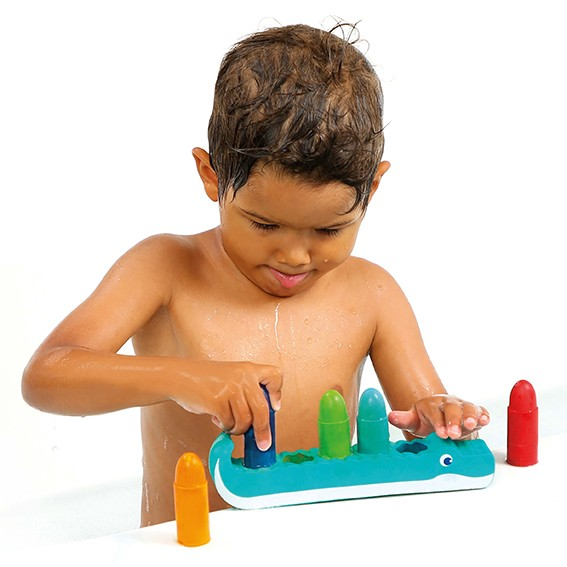 Criança a brincar com brinquedo de crocodilo colorido em fundo branco