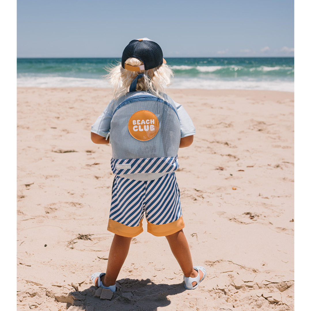 Criança com mochila Beach Club na praia