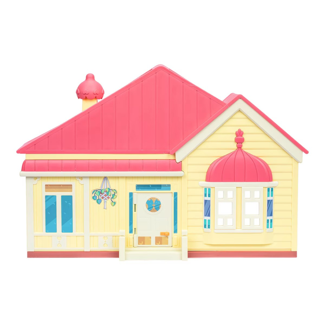Casa de brinquedo amarela e rosa com tecto e chaminé vermelhos e porta azul