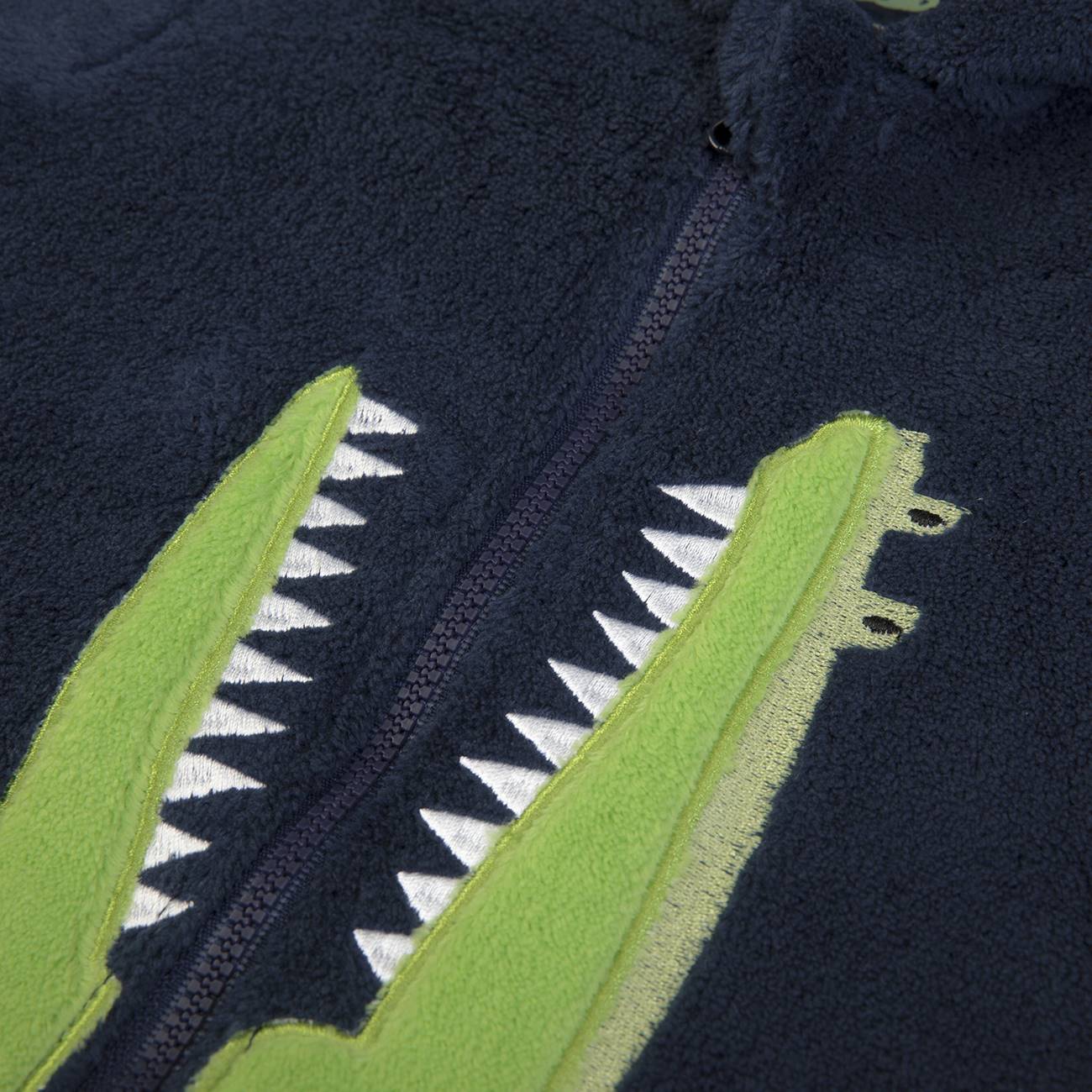 Casaco azul escuro com fecho e desenho de boca de crocodilo em verde e branco