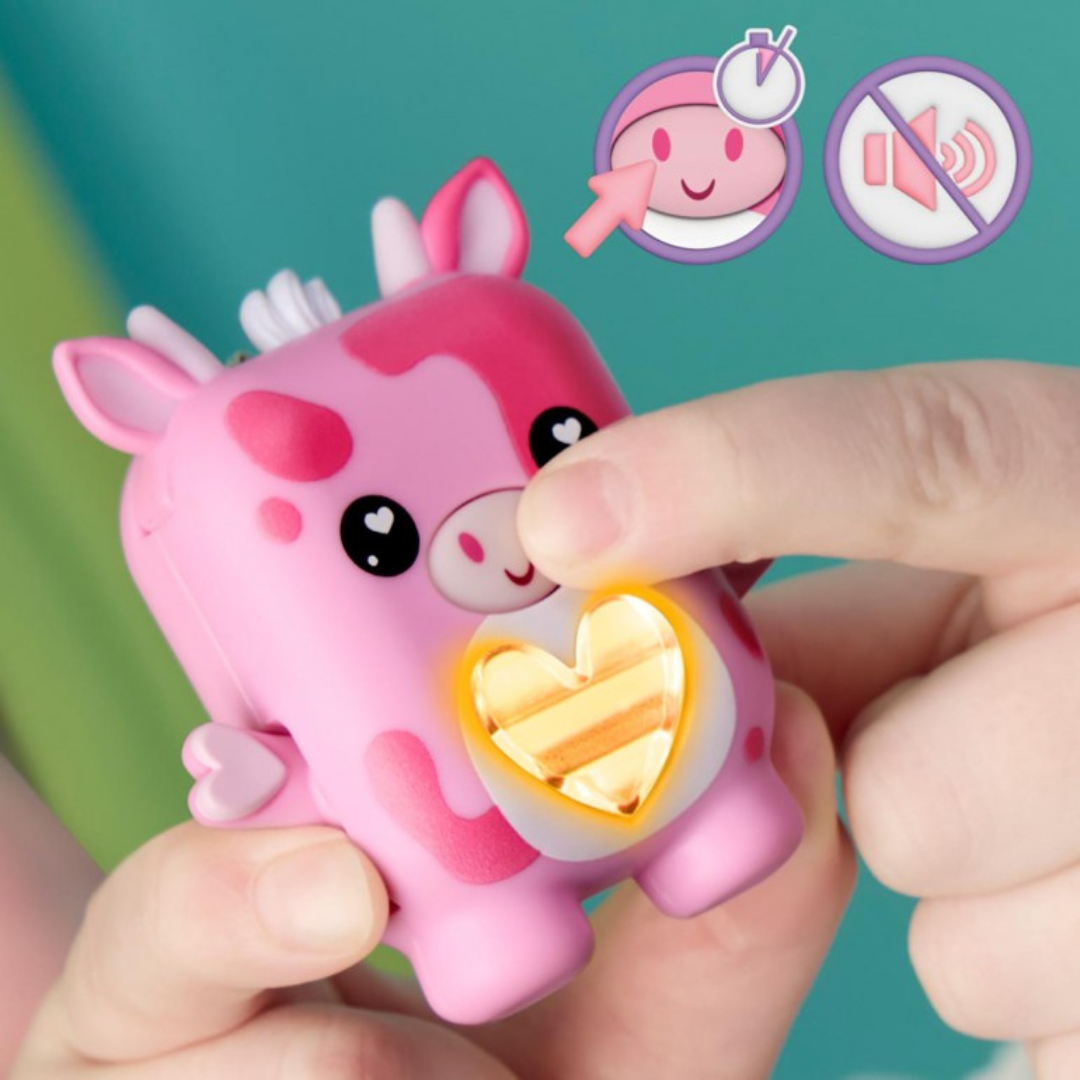 Brinquedo de vaca rosa com coração iluminado sendo pressionado por um dedo