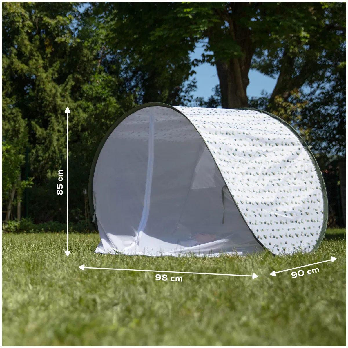 Tenda branca com padrão de folhas pretas em relva verde