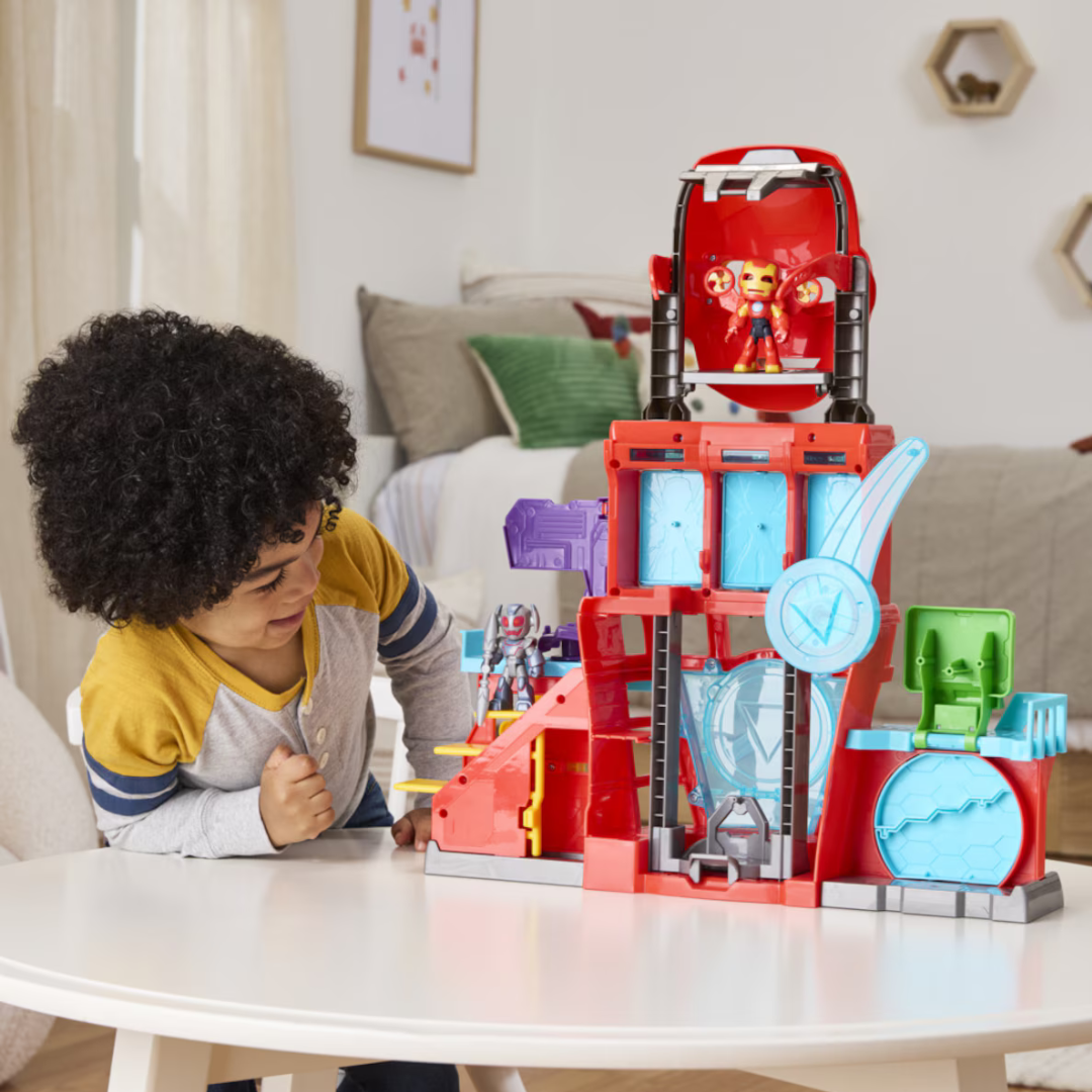 Brinquedo de construção vermelho e azul com figuras de super-heróis e criança a brincar.