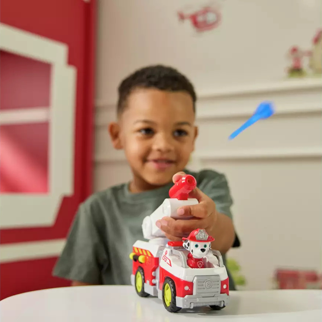 Menino a brincar com carrinho de bombeiros a disparar dardo azul