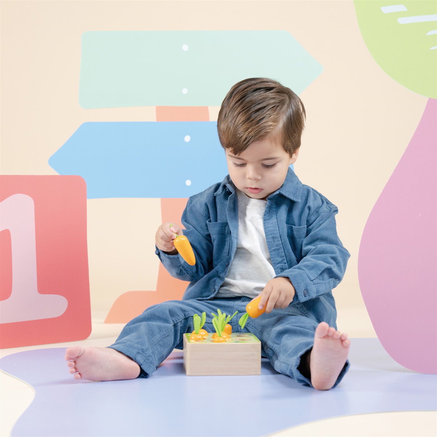 Criança a brincar com brinquedo de madeira cenouras.