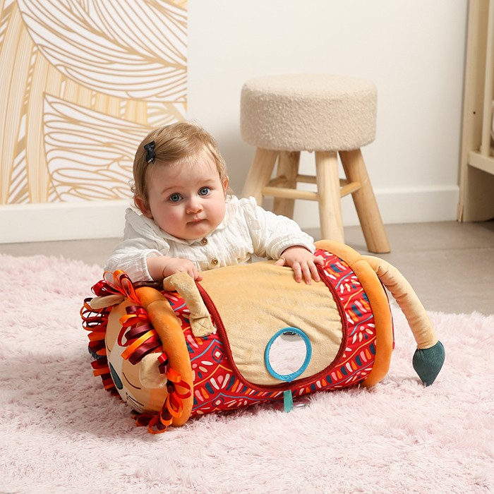 Brinquedo em forma de rolo com bebé sentado ao lado