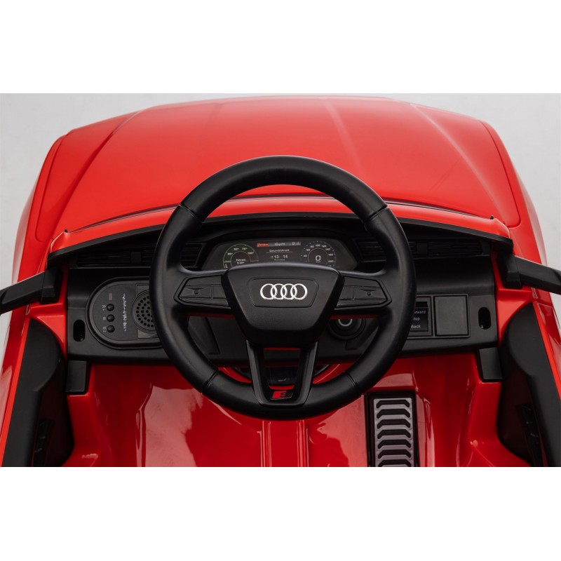 Interior de brinquedo de carro vermelho com volante preto e painel digital.