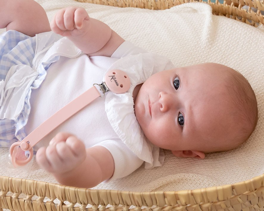 Bebé de body branco com fita prendedor de chuchas cor-de-rosa