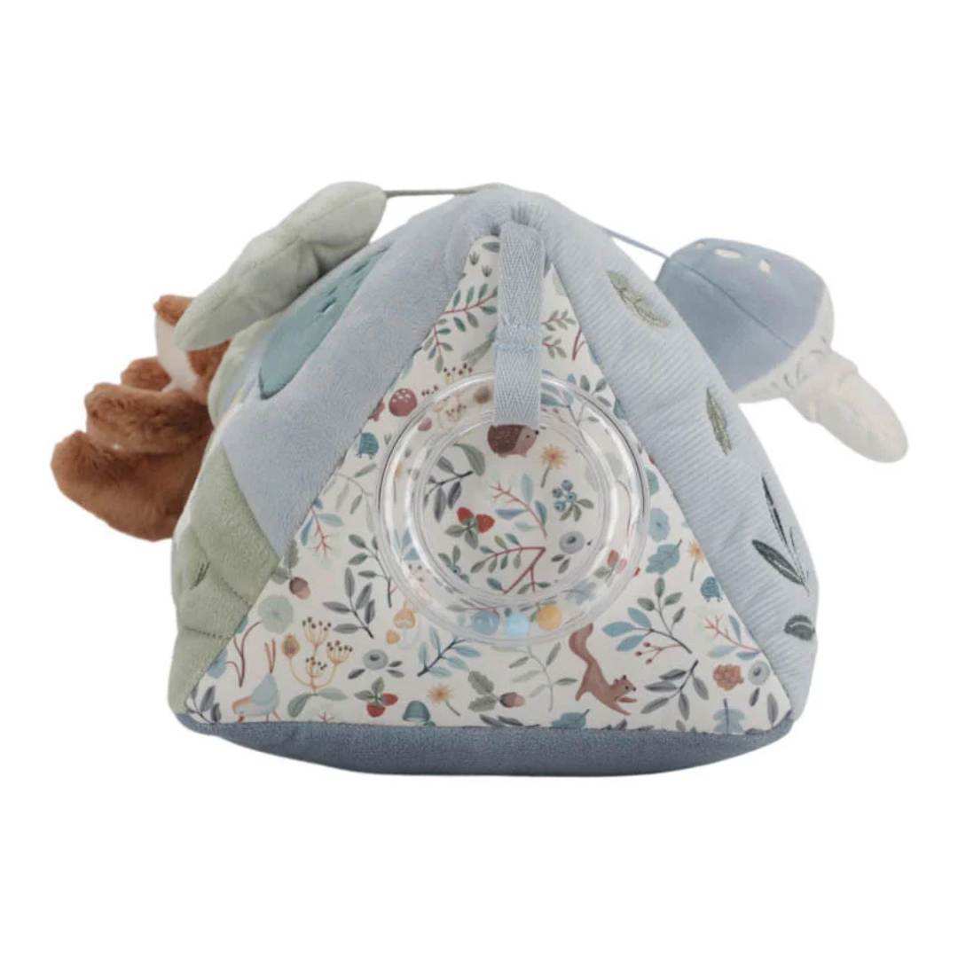 Brinquedo sensorial triangular em tecido macio azul e verde com padrão floral colorido e argola transparente.