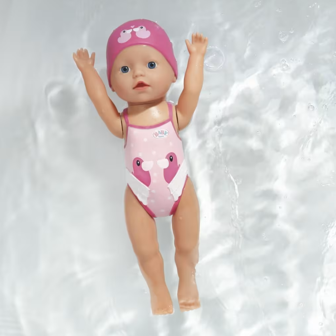 Boneca bebé com fato de banho e touca rosa com flamingos a flutuar na água