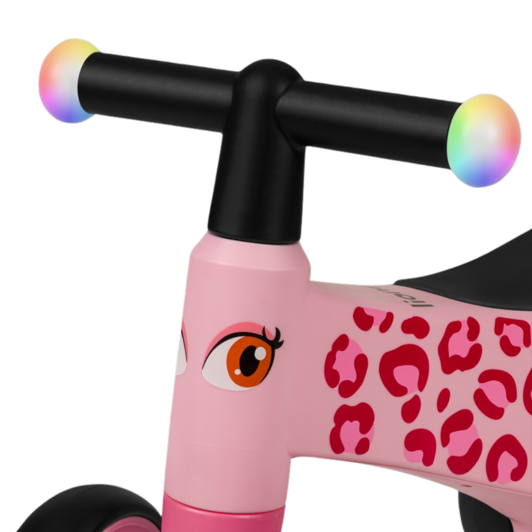 Bicicleta infantil rosa com padrão leopardo e guiador preto com tampas coloridas