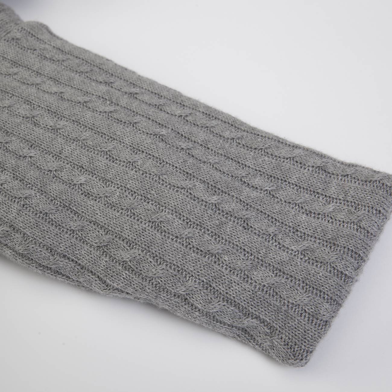 Cachecol cinzento de malha com padrão de tranças sobre fundo branco