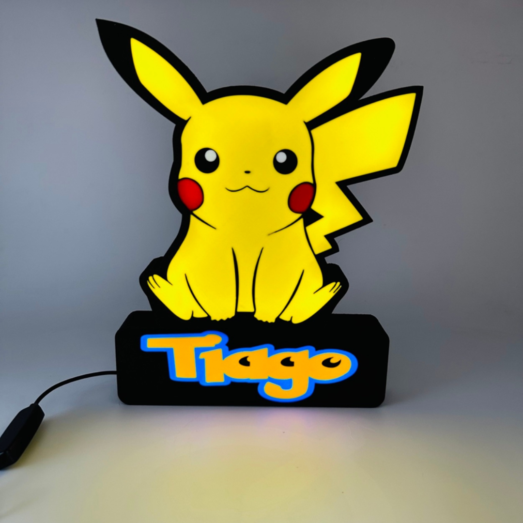 Luminária de mesa com Pikachu amarelo e base preta iluminada com o nome Tiago