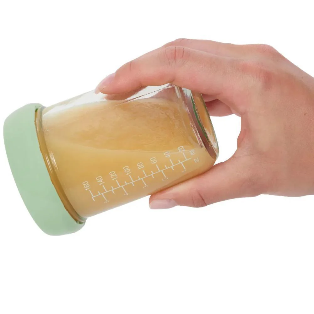 Frasco de vidro com líquido amarelo e tampa verde claro na mão