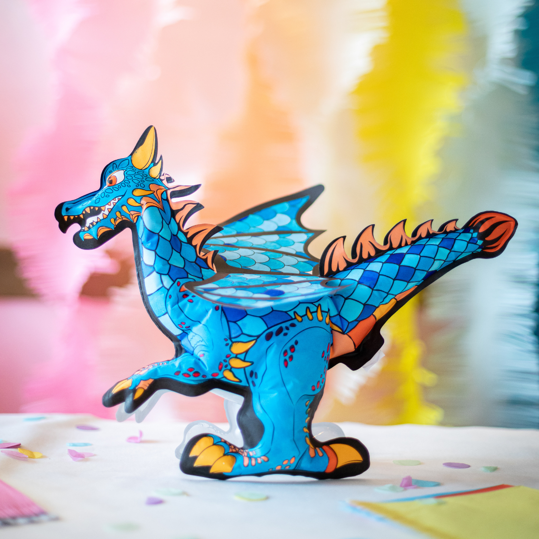 Dragão de brinquedo têxtil azul com asas e detalhes coloridos em fundo desfocado colorido