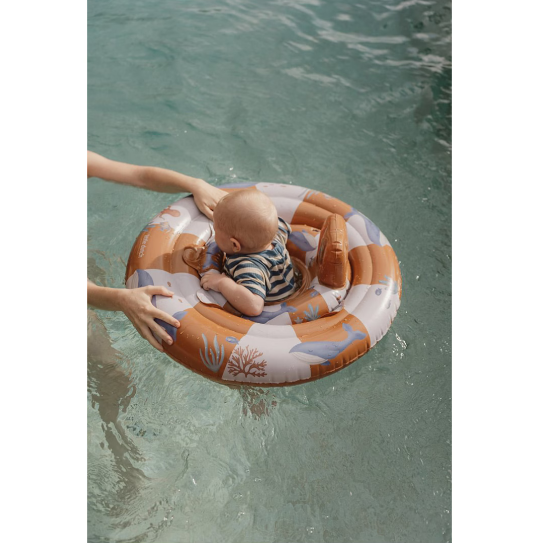 Bebé em flutuador insuflável infantil com padrão marinho em piscina