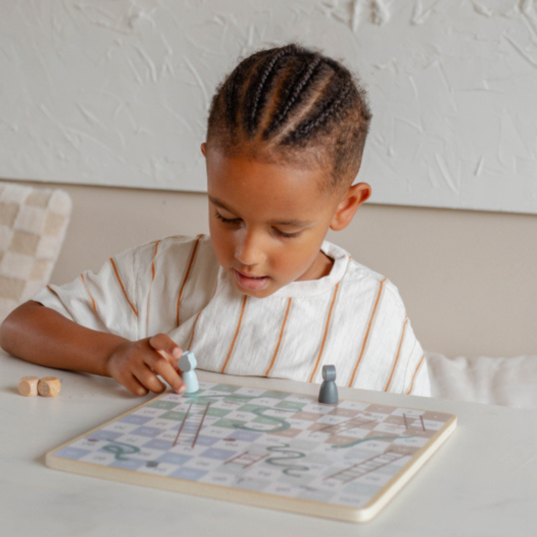 Criança a jogar jogo de tabuleiro em mesa branca