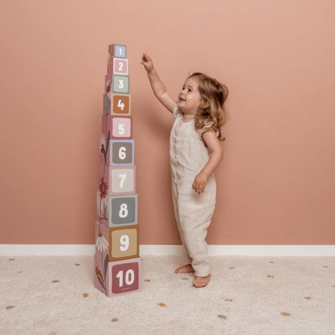 Criança brincando com blocos empilhados numerados e coloridos