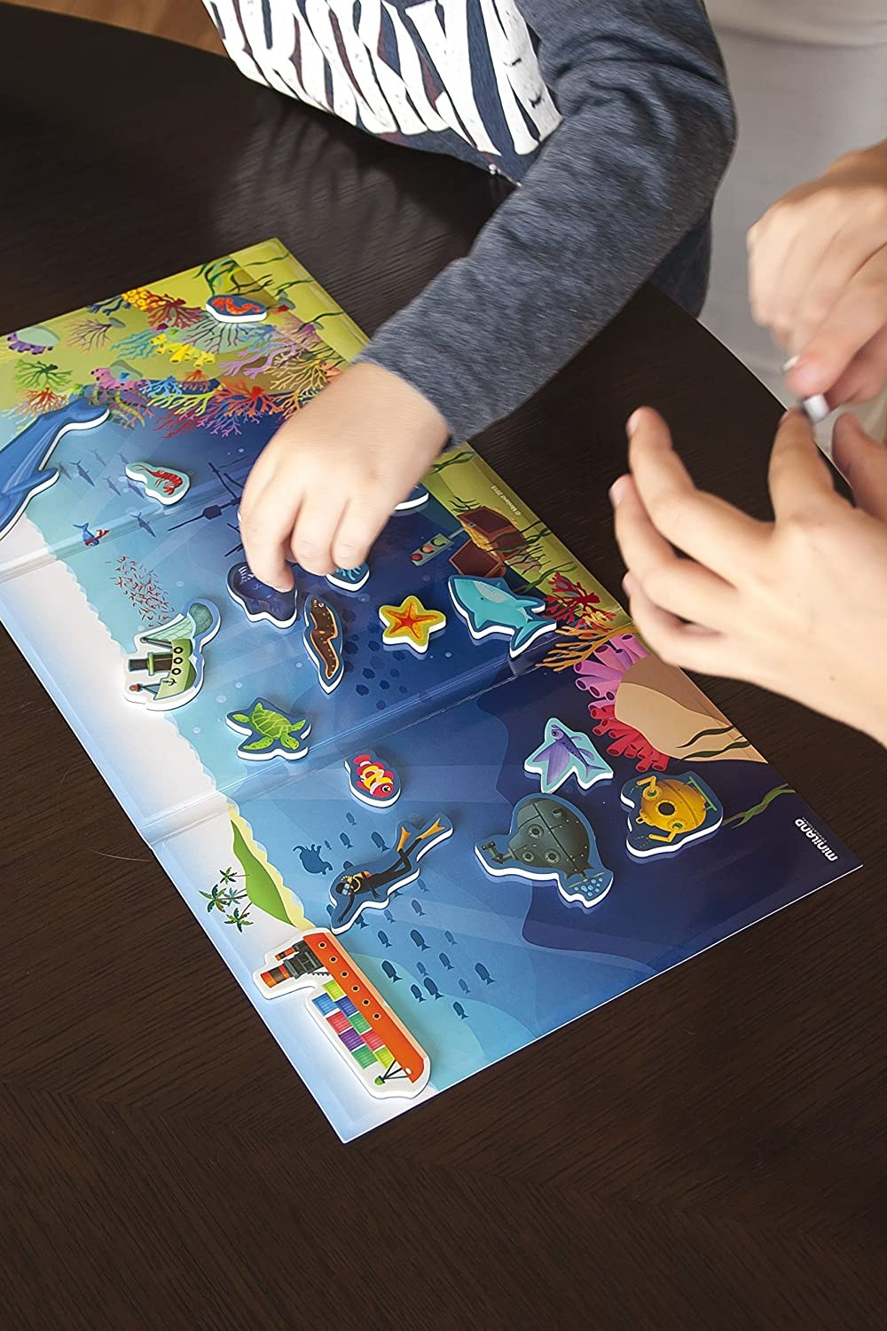 Quebra-cabeça magnético infantil de vida marinha sobre mesa de madeira