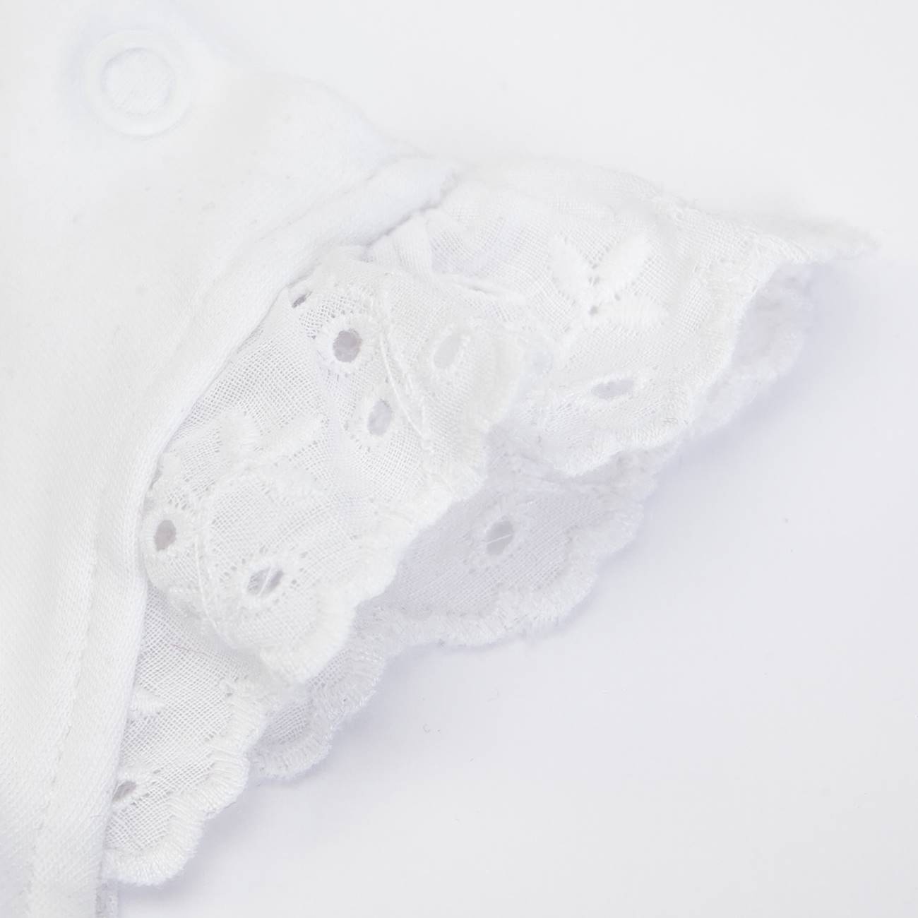 Peça de vestuário branca com renda bordada e botão de pressão em detalhe